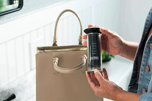 woman holding flosser saucer near purse