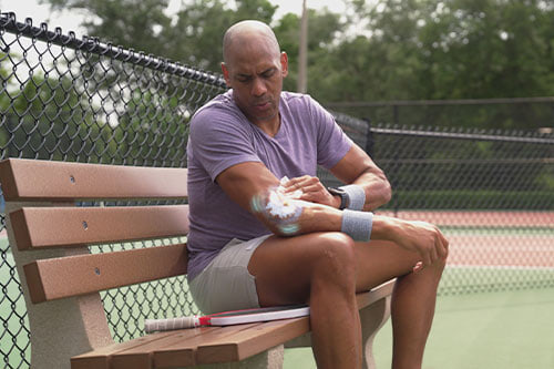 man using ice wipes on bench