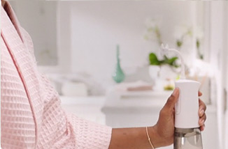 Mujer usando Miracle Smile&reg; en la ducha